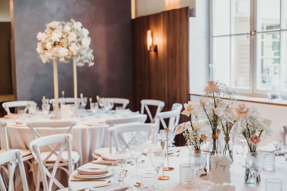 Eine elegant gedeckte Hochzeitstafel mit Blumen, Kerzen und feinem Gedeck